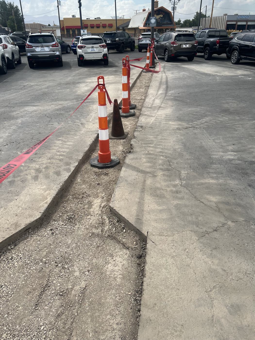 A straight slab saw cut running across a commercial parking lot in the Salt Lake area