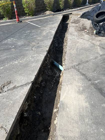 A clean saw cut opened up for a utility line under a parking lot