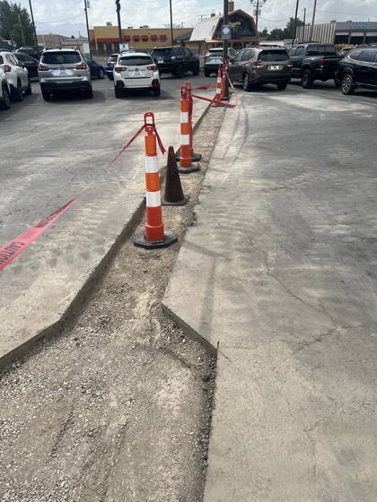 A straight slab saw cut running across a commercial parking lot
